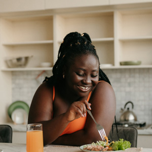 Woman smiling while eating meal at home