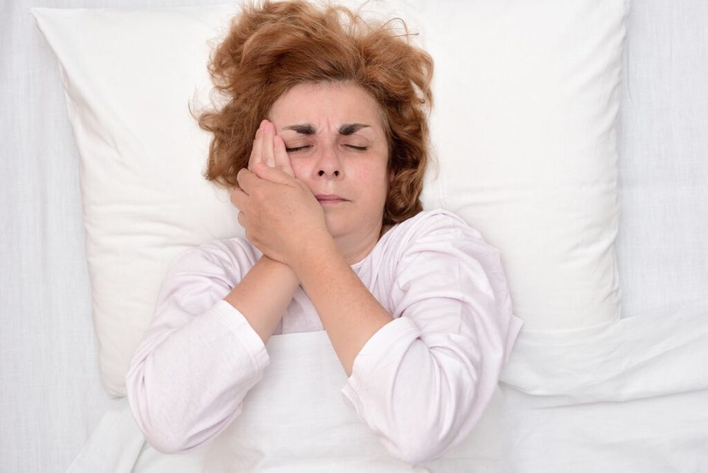 A woman trying to sleep with a toothache