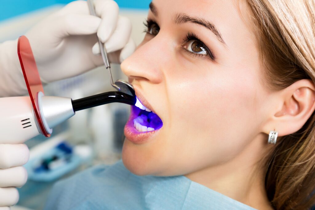 Dentist applying UV light to patient's dental bonding