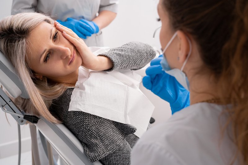 Lady with toothache looks to dentist